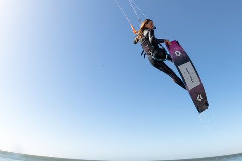 Duotone Soleil Textreme twin-tip kiteboard during kitesurfing at an ocean beach