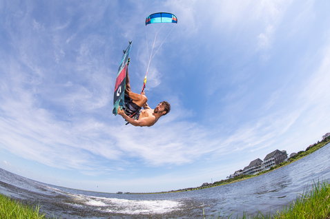 Duotone Spike Textreme twin-tip kiteboard 153cm durante il kitesurf su laguna costiera con riva erbosa