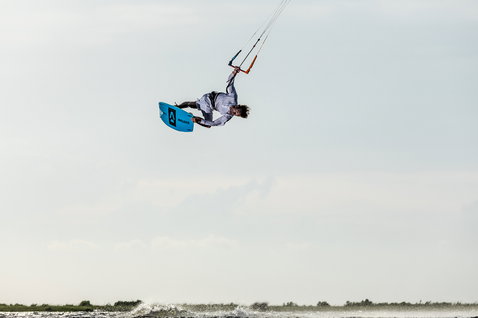 Duotone Kiteboarding Gambler 2020 wake-style kiteboard durante il kitesurf in una laguna piatta