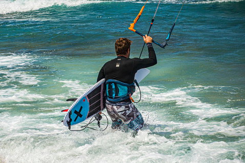 Duotone Pro Session directional kiteboard durante il kitesurf su una spiaggia oceanica con onde