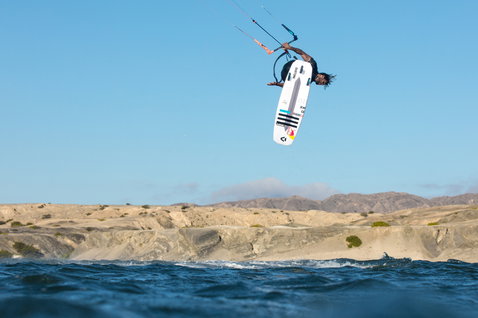 Duotone Pro Voke strapless surfboard during kitesurfing at the rocky ocean coastline