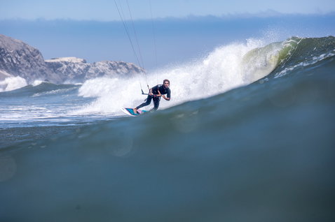 Duotone Pro Wam kiteboard de vagues en train de faire du kitesurf sur la plage rocheuse