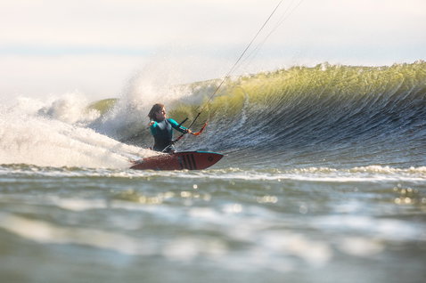 Duotone Wam wave kiteboard during wave riding at an ocean beach