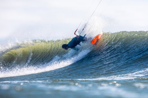 Duotone Wam wave kiteboard during wave riding at an ocean beach