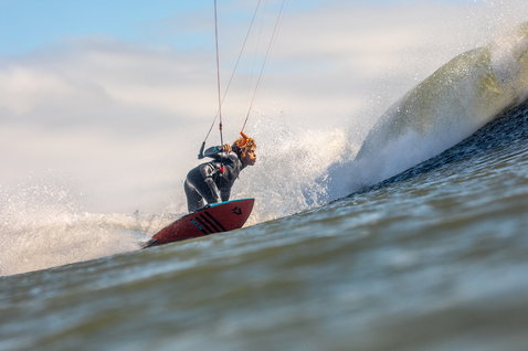 Duotone Wam wave kiteboard during wave riding at an ocean beach