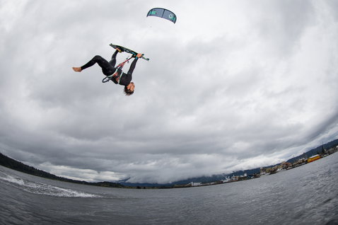 Duotone Evo LEI Kite beim Kitesurfen auf einem See mit entfernter Küstenlinie und Jachthafen