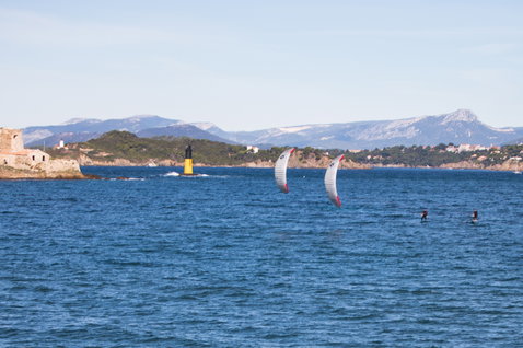 Duotone Capa Foil-Kite beim Foilen in einer Küstenbucht mit Felseninsel und Leuchtturm