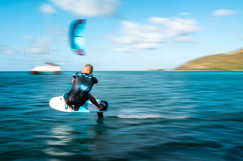 Duotone Daytona 105 tabla de kite foil durante el foiling en una laguna oceánica tropical