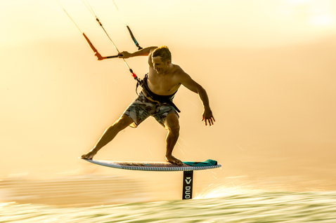 Duotone Hybrid kite surfboard durante el kitesurf en aguas planas en el océano