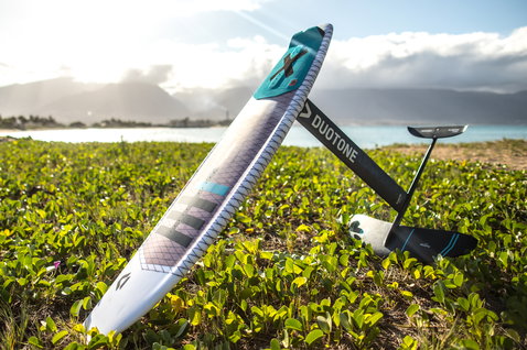 Duotone Hybrid tabla de kite surfboard durante kitesurf en praderas costeras con océano y montañas al fondo