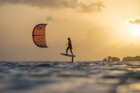 Duotone Mono LEI kite durante el foil en una costa tropical con silueta de árbol