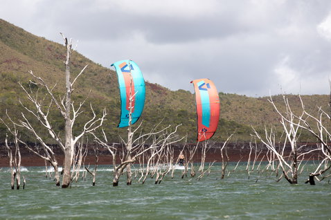 Duotone Juice 2020 LEI Kite beim Kitesurfen in einer überfluteten Lagune mit kahlen Bäumen und Bergen