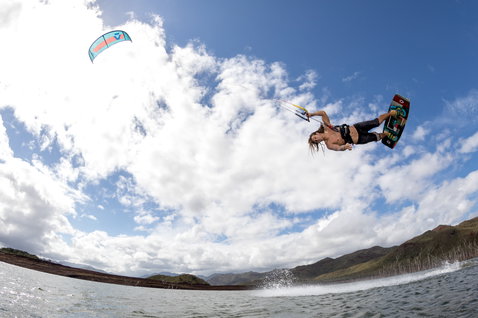 Duotone Juice LEI Kite beim Kitesurfen an einem Binnensee mit Bergpanorama im Hintergrund