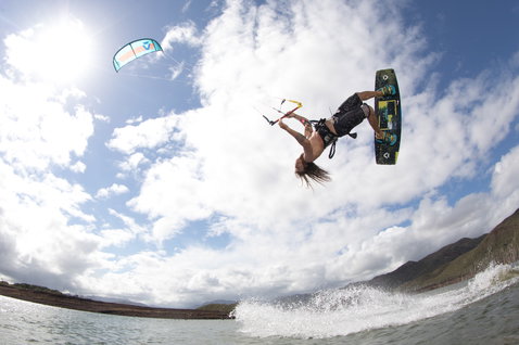 Duotone Juice LEI Kite beim Kitesurfen am Strand mit Bergen im Hintergrund