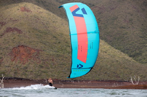 Duotone Juice LEI Kite beim Kitesurfen an einem Binnensee mit roter Erde und Hügeln