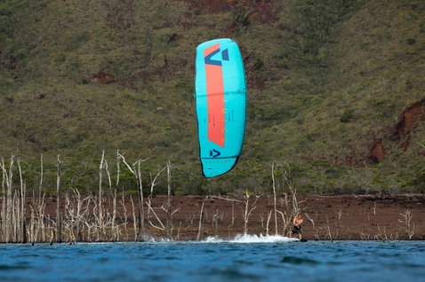 Duotone Juice LEI Kite beim Kitesurfen an einem Binnengewässer mit roter Erde und Vegetation