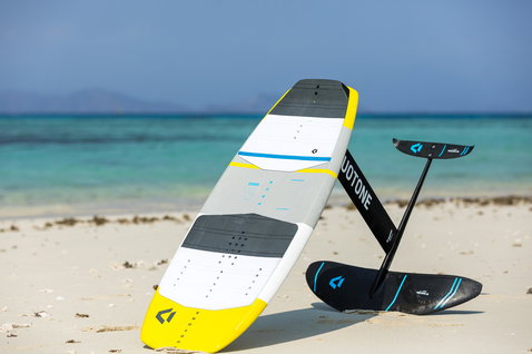 Duotone Pace Foil Kiteboard in weiß mit gelb, grau, schwarz und blau am tropischen Strand