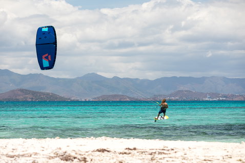 Duotone Pace Foil Kiteboard beim Foilen am tropischen Ozean mit Bergkulisse