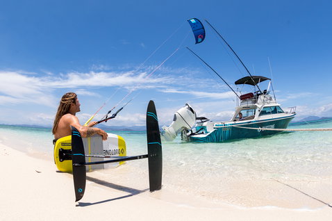 Duotone Pace Foil Kiteboard beim Kitesurfen an einem tropischen Strand mit klarem Flachwasser