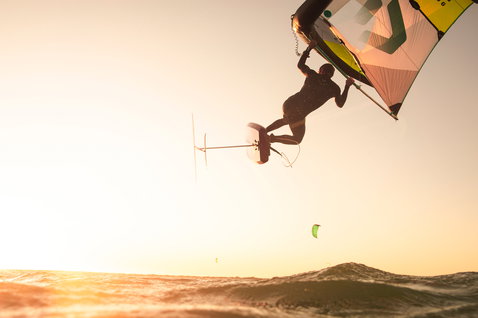 Duotone Echo foil wing en action wing foiling en vol au-dessus de l'océan au coucher du soleil