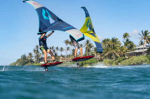 Duotone Unit foil wing durante il wing foiling sull'oceano in blu marino e giallo-verde