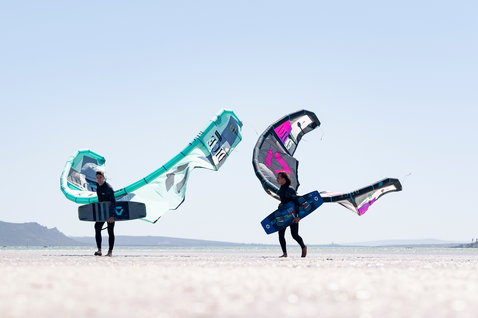 Duotone Dice kite LEI durante il kitesurf su una spiaggia dell'oceano con riva sabbiosa piatta