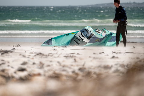 Duotone Dice LEI kite durante il kitesurf su una spiaggia oceanica