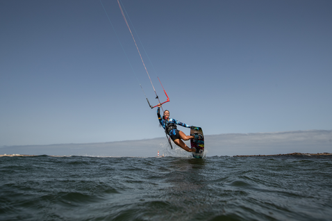 Duotone Trust Bar Quad Control barre de contrôle en train de faire du kitesurf en océan ouvert avec côte lointaine