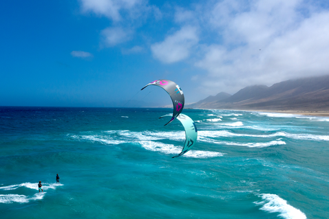 Duotone Neo SLS LEI Kite beim Wellenreiten an einem Meeresstrand