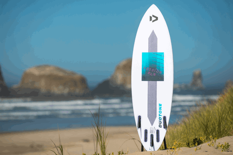 Duotone Session SLS kite surfboard durante el kitesurf en la playa con dunas