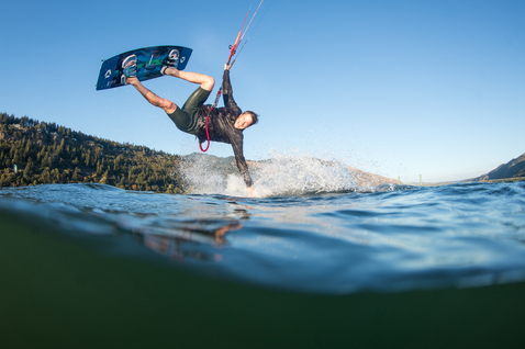 Duotone Jaime SLS twin-tip kiteboard lors d'une session de kitesurf sur un lac avec collines boisées