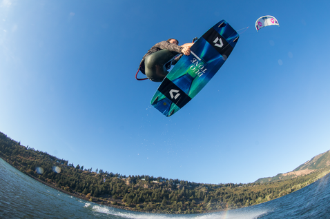 Planche de kitesurf twin-tip Duotone Jaime SLS en action lors de kitesurf sur un lac avec montagnes boisées
