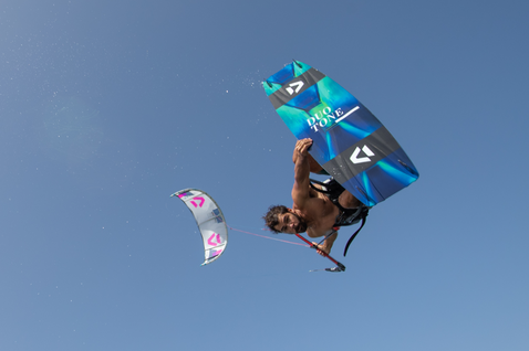 Planche de kitesurf twin-tip Duotone Jaime SLS en action lors de kitesurf sous un ciel dégagé sur l'eau