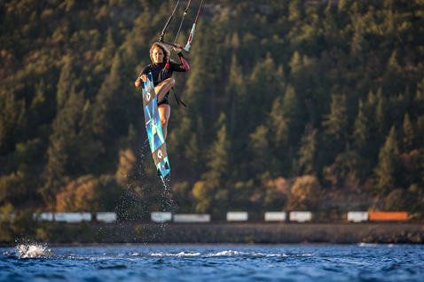 Duotone Jaime SLS kiteboard twin-tip lors du kitesurf dans une gorge fluviale avec collines boisées