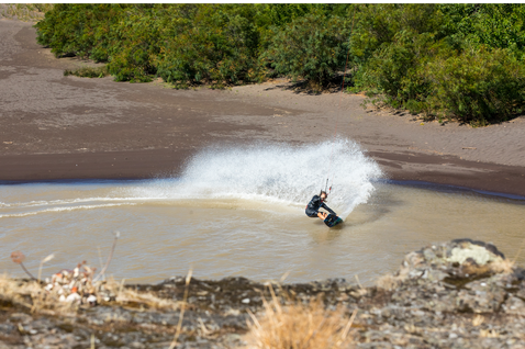 Duotone Jaime SLS twin-tip kiteboard lors d'une session de kitesurf sur rivière peu profonde aux berges sablonneuses