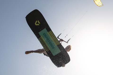 Tabla de kitesurf twin-tip Duotone Ultraspike SLS durante el kitesurf en la playa del océano vista aérea