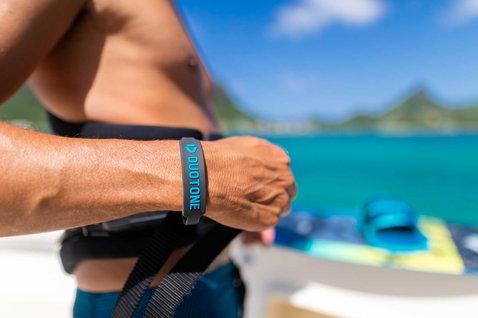 Duotone Kiteboarding wristband during kitesurfing on the ocean beach with tropical island backdrop
