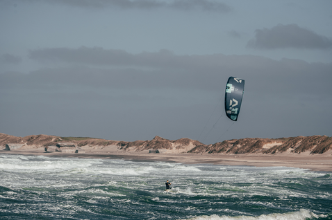 Duotone Evo SLS LEI kite durante el kitesurf en la playa con dunas de arena