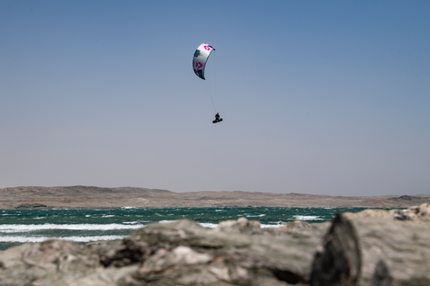 Duotone Evo SLS LEI kite durante el kitesurf en una costa rocosa con océano
