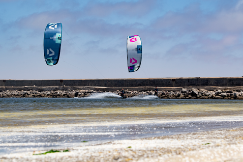 Duotone Evo SLS LEI kite durante el kitesurf en una laguna costera con rompeolas de piedra