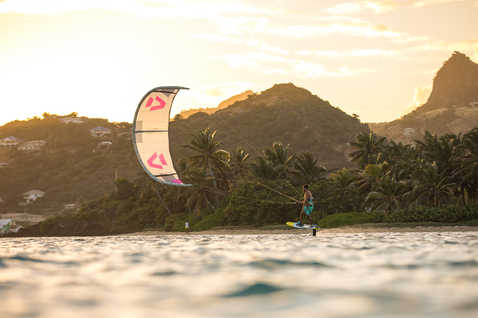 Duotone Juice LEI Kite beim Kitesurfen an einem tropischen Strand mit Bergen und Palmen