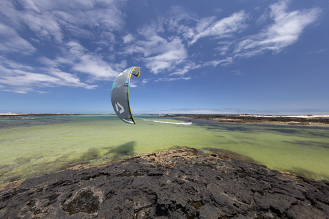 Duotone Juice D/LAB LEI Kite beim Kitesurfen an einer felsigen Küstenlagune
