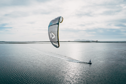 Duotone Juice D/LAB LEI Kite beim Kitesurfen auf einem Flachwasser-Lagunen mit fernen Bergen