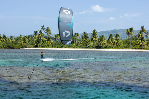 Duotone Juice D/LAB LEI Kite beim Kitesurfen in einer tropischen Lagune mit Palmen und türkisblauem Wasser