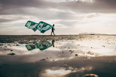 Kite LEI Duotone Vegas durante il kitesurf su una pianura tidale costiera con riflessi d'acqua