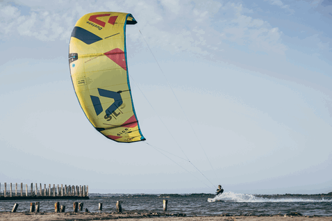 Duotone Dice SLS LEI kite during kitesurfing on coastal flatwater with wooden pier visible
