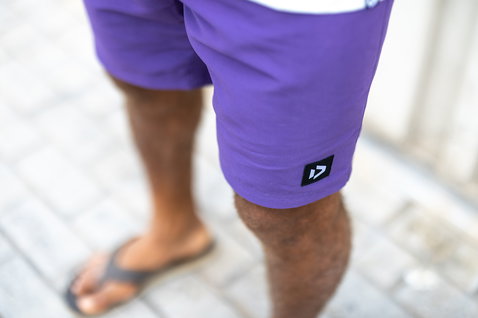 Duotone boardshorts en violet prune sur un trottoir urbain carrelé en extérieur