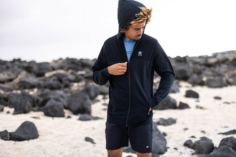 Duotone Apparel Zip-Hoodie in schwarz beim Tragen am Vulkanstrand der Kanarischen Inseln