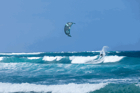 Duotone Neo SLS LEI kite durante el surf de olas en el océano en costa tropical