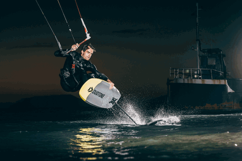 Duotone Pace SLS planche de kite foil lors de foiling en eau libre dans un port de nuit